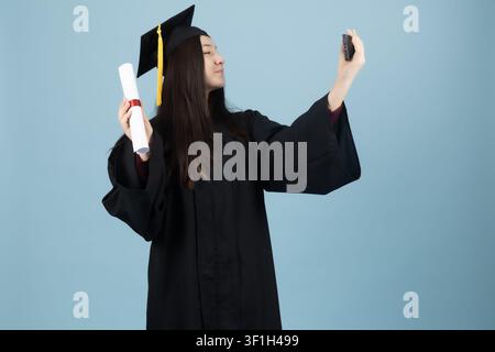Female graduate student taking selfie photo with mobile smartphone Stock Photo
