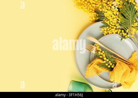 Stylish spring composition with mimosa flowers and ceramic plates Stock Photo