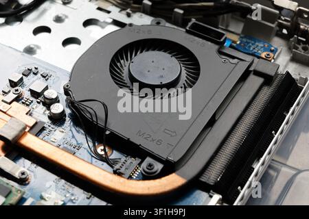 Cooling fan and copper heat pipe close-up of a notebook computer. Components inside a consumer laptop during maintenance and repair. Stock Photo