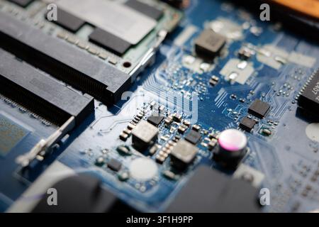 Electronic components of notebook close-up. Detail of circuit board of computer. Technical maintenance and disassembly and repair of laptop. Stock Photo