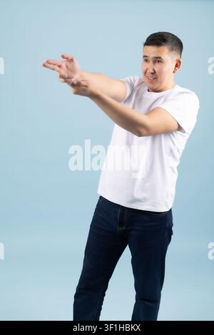 Young cheerful man pointing fingers forward directing your focus Stock Photo