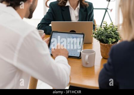 Business professional analyzing growing charts on digital tablet Stock Photo