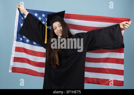 Proud female graduate holding the american flag behind her back Stock Photo