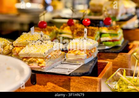 Assorted traditional Basque pintxos displayed on a bar counter in Bilbao, Spain. Stock Photo