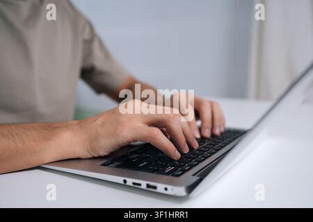 Close-up hands typing on laptop keyboard, representing productivity, remote work, online learning, digital communication and professional activity in Stock Photo