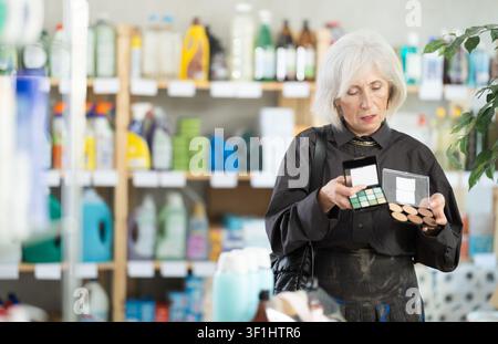 Elderly woman choosing cosmetics in household chemicals store Stock Photo