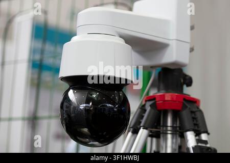 Modern PTZ security surveillance camera with motorized pan, tilt and zoom functions mounted on a professional support. Stock Photo