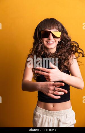 Young woman dancing with confidence wearing stylish shades Stock Photo