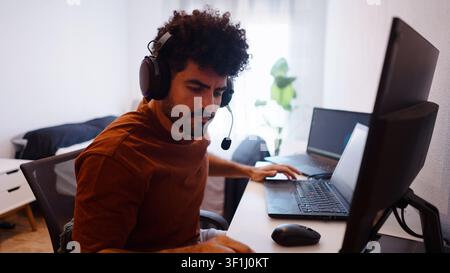 Young man working remotely from home at his computer setup Stock Photo