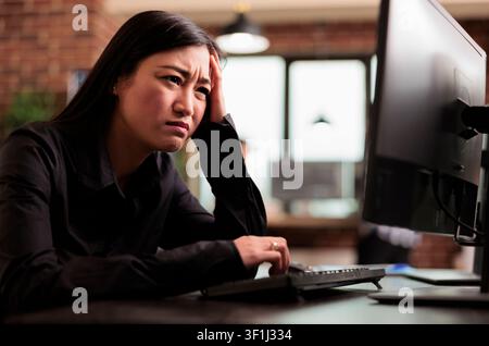 Overworked tech engineer struggles with development pressure around computer screens, showing developer teamwork, source code discussion and cloud programming workflow. Stock Photo
