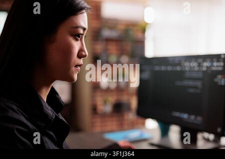 System engineer writes JavaScript terminal code on a terminal window while programming HTML, JavaScript and data algorithms for cloud computing inside a company office. Stock Photo