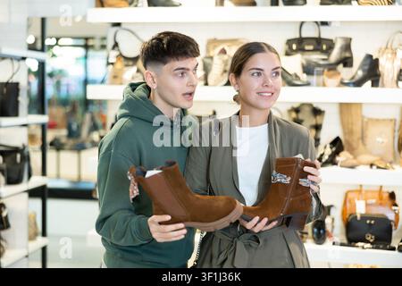 Couple man and woman choosing ankle boots in store Stock Photo