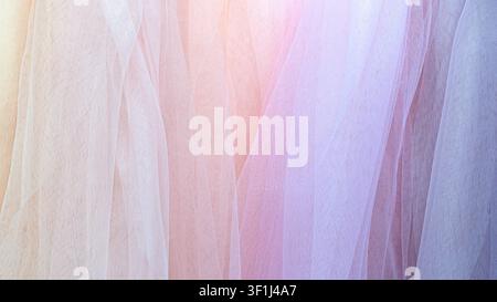Sheer white mesh fabric with soft folds. Pastel colors blend gently across layers. Diffused light creates glowing effect. Fine weave texture appears d Stock Photo
