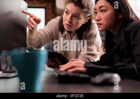 System engineers discuss a cloud coding project in a software office, collaborating on programming algorithms and user interface development. Stock Photo