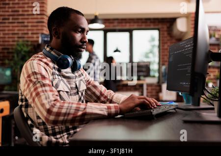 Freelance coder typing javascript code on computer to develop online cloud computing information. Software developer writing html script and data algorithm, working in it programming office. Stock Photo