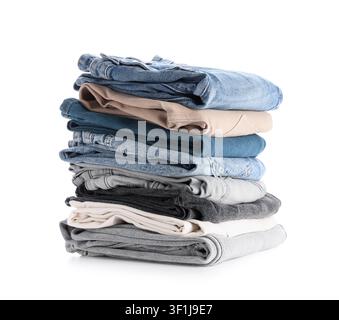 Stack of folded denim jeans and casual trousers in various colors, isolated on a clean white background, the clothing items are made from different te Stock Photo