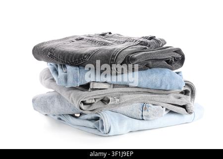 Stack of folded denim jeans in various shades of blue and gray, casual clothing and fashion concept, isolated on a white background Stock Photo