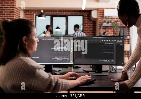 Programming engineers write code on computers to develop algorithm programs, user interface scripts and terminal workflow inside a software development company. Stock Photo