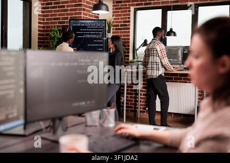 Developers analyze machine learning application code, combining programming code, software teamwork and digital infrastructure inside a technology office. Stock Photo