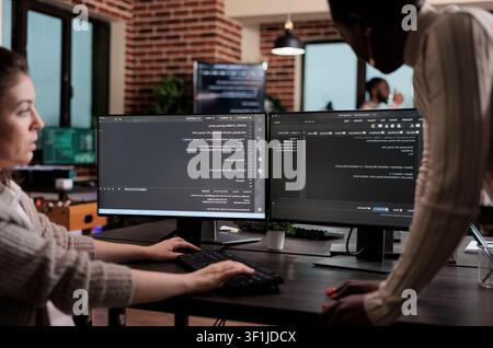 Diverse cybersecurity employees optimize mainframe processing methods and defend a database system by developing an advanced firewall mechanism. Stock Photo