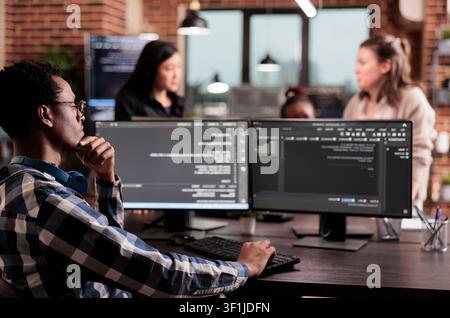 Technology engineer types server code on a computer in an IT agency while creating an online system algorithm and new user interface. Stock Photo