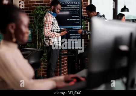 Programmer team searches for cyberattack sources and security coverage while developing encryption applications for digital protection. Stock Photo
