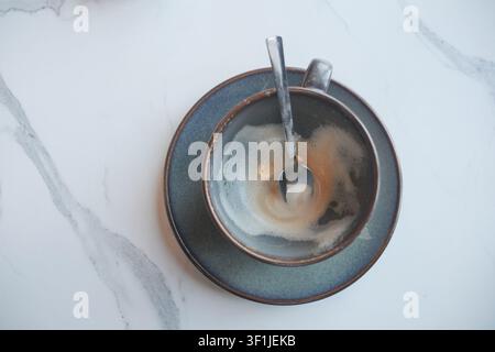 Cup sits empty on a table after coffee was enjoyed Stock Photo