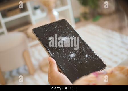 Broken tablet screen in a living room setting Stock Photo
