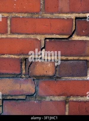Cracked brick and cement mortar. Cracked masonry texture for construction design background. Brick joint separation in aging exterior wall. Building Stock Photo