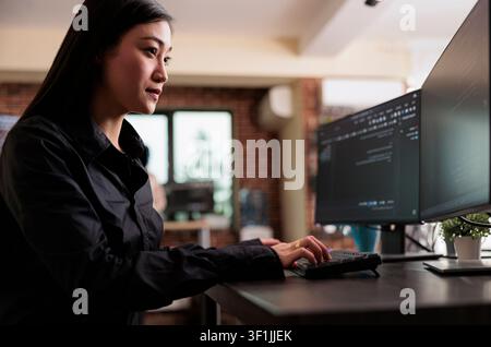 Cybersecurity employee developing blockchain database system during a focused IT task involving diagnostics, digital infrastructure and secure data processing. Stock Photo