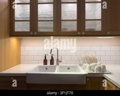 Modern Farmhouse Kitchen Sink with Drying Rack and Wooden Cabinets Stock Photo