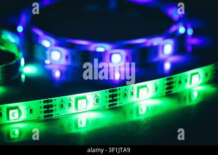 Green and Purple LED Strip Lights Glowing on Reflective Surface Close Up Stock Photo