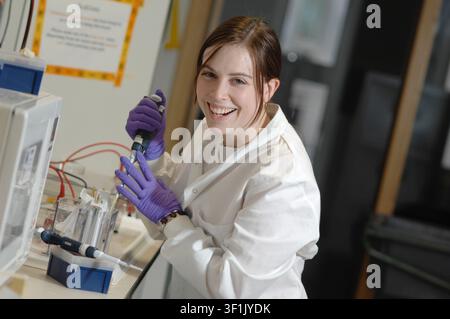 A female scientist using a pipette in a lab. Stock Photo