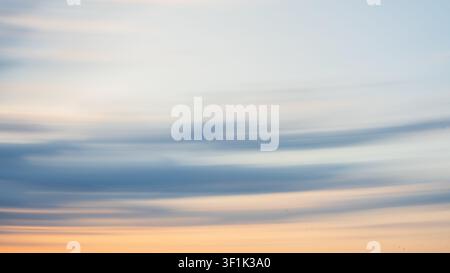 An abstract background created with ICM Intentional Camera Movement technique, showcasing flowing light and soft textures in sunset colours. Stock Photo