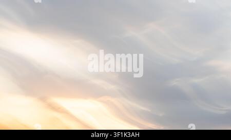 Abstract intentional camera movement ICM background resembling flowing light and soft textured clouds in vibrant sunset colours of blue and orange. Stock Photo