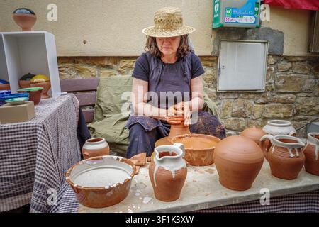 Castellgali - Spain - May, 2, 2026: Woman Artisan Making Clay Pot On Pottery Wheel At Outdoor Craft Market, Traditional Ceramic Jugs, Handmade Worksho Stock Photo