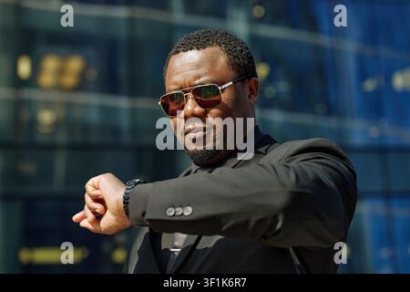 Black Middle Aged Businessman Checking Time before Meeting Stock Photo