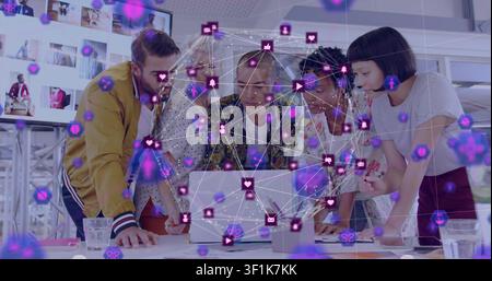 Design team leaning over laptop tapping screen, sparking network overlay over laptop for review Stock Photo
