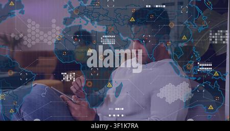Man tapping tablet in lounge, starting faint map overlay growing into dense AR HUD, analyzing data Stock Photo