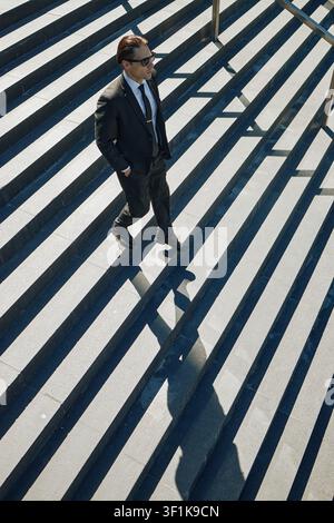 Businessman Walking down Stairs in Urban Corporate Commute Stock Photo