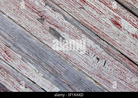 Weathered wood planks show faded red and gray paint. Peeling layers reveal rustic, aged texture. Cracks and scratches hint at time's passage. Perfect Stock Photo