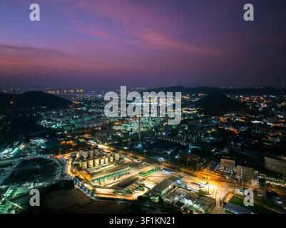 A panoramic night view of a large petrochemical industrial complex featuring illuminated storage tanks and infrastructure in si racha chonburi thailan Stock Photo