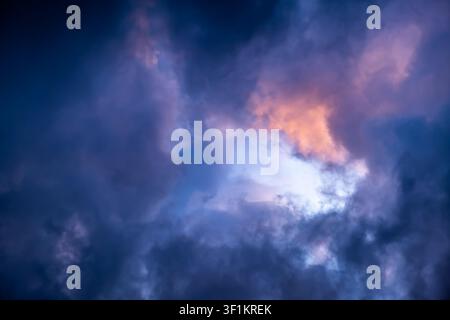 Blue hole in the dark cloudy sky. Storm Clouds. Evening sunset. Rainy and stormy weather. Art wallpaper. Natural landscape. Beauty in nature. After Stock Photo