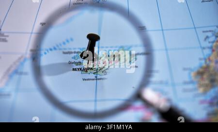 Reykjavik marked on a printed map, using a magnifying glass. Stock Photo