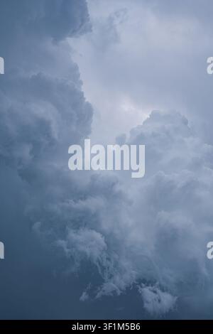 Vertical view of dark dramatic cumulonimbus storm clouds in the sky Stock Photo