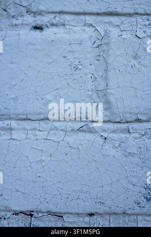Vertical close up of an old wooden surface with heavily cracked and peeling light blue paint Stock Photo