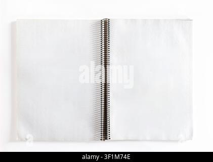 Top view of an open blank spiral notebook with white paper sheets isolated on a white background. Stock Photo