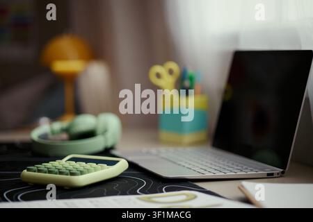 Close up of laptop with calculator and headphones supporting home budgeting, online learning, or remote work setup. Useful for finance, productivity, or digital lifestyle marketing Stock Photo