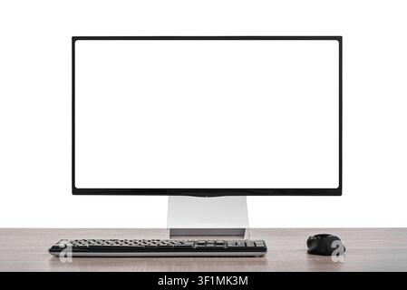 A modern computer monitor with a blank white screen sits on a wooden desk alongside a black keyboard and mouse against a white background. Stock Photo