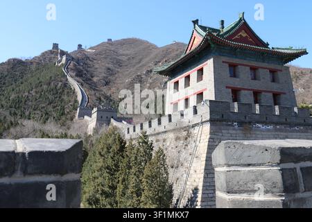 The Great Wall of China winding across mountain ridges under a blue sky near Beijing, China. Low angle from the temple's view Stock Photo